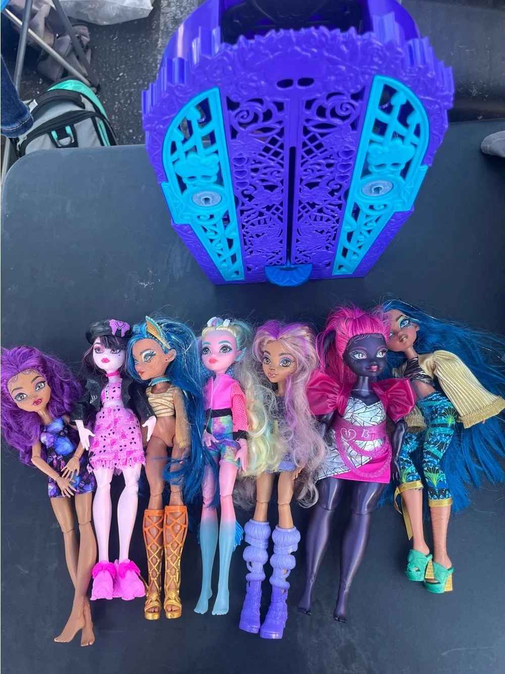 monster high dolls set with purple, teal, pink and blue carrier